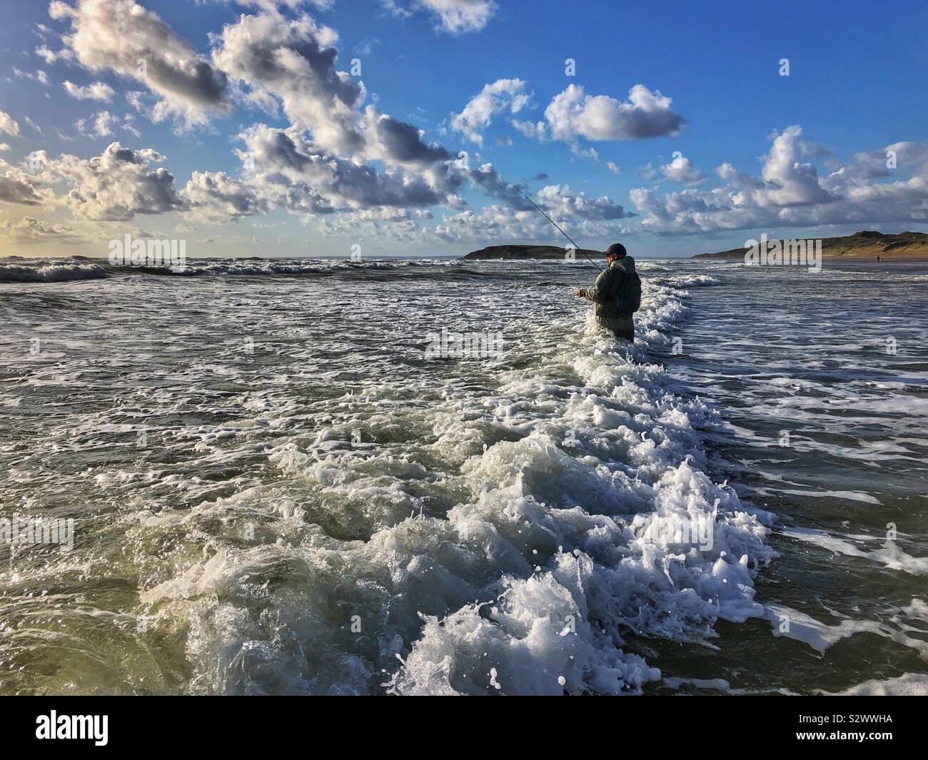 La pêche des pêcheurs pour la basse dans le surf à Llangennith, Gower, Swansea, Pays de Galles du sud-ouest. Banque D'Images