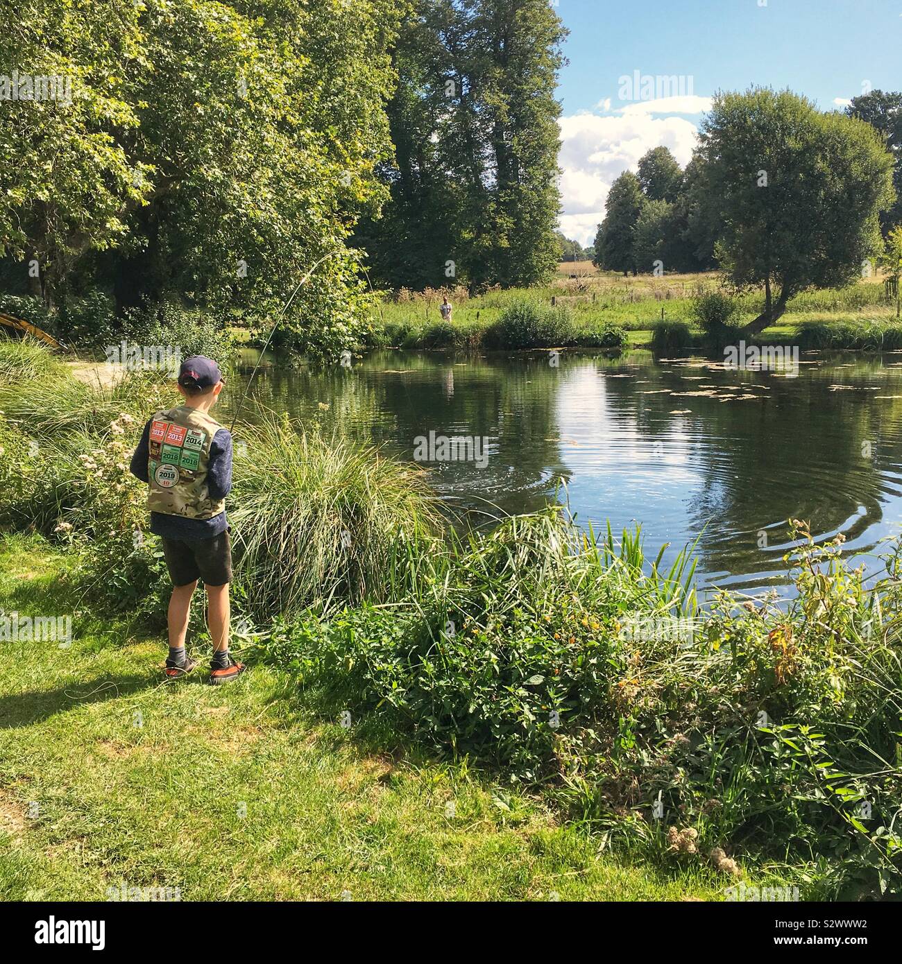 Garçon de dix ans à l'atterrissage et les poissons à la pêche à la truite Avington Avington,Parc, Winchester, Hampshire, Angleterre, Royaume-Uni. Banque D'Images