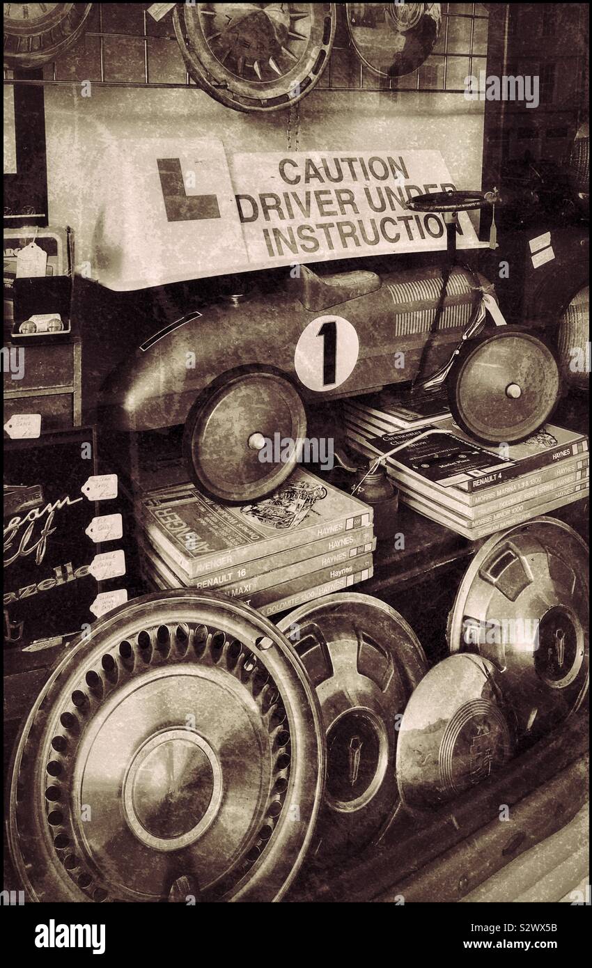 Un affichage vitrine représentant un thème de l'automobile. Enjoliveurs, manuels, toys & signes constituent la composition. Crédits photos - © COLIN HOSKINS. - Image de stock capturée avec un smartphone