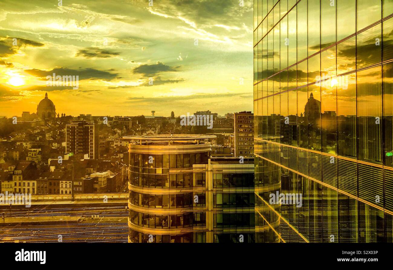 Lever tôt le matin dans un ciel coloré et spectaculaire, qui se reflète dans la vitre d'un immeuble de bureaux dans le quartier financier de la ville - Image de stock capturée avec un smartphone