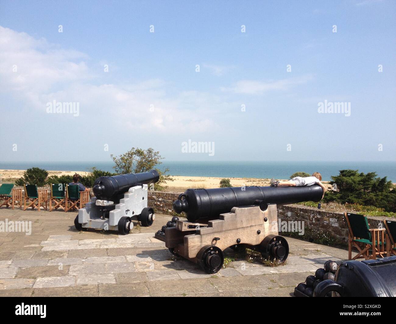 Un enfant portant sur un canon au château de Walmer dans la côte du Kent Banque D'Images