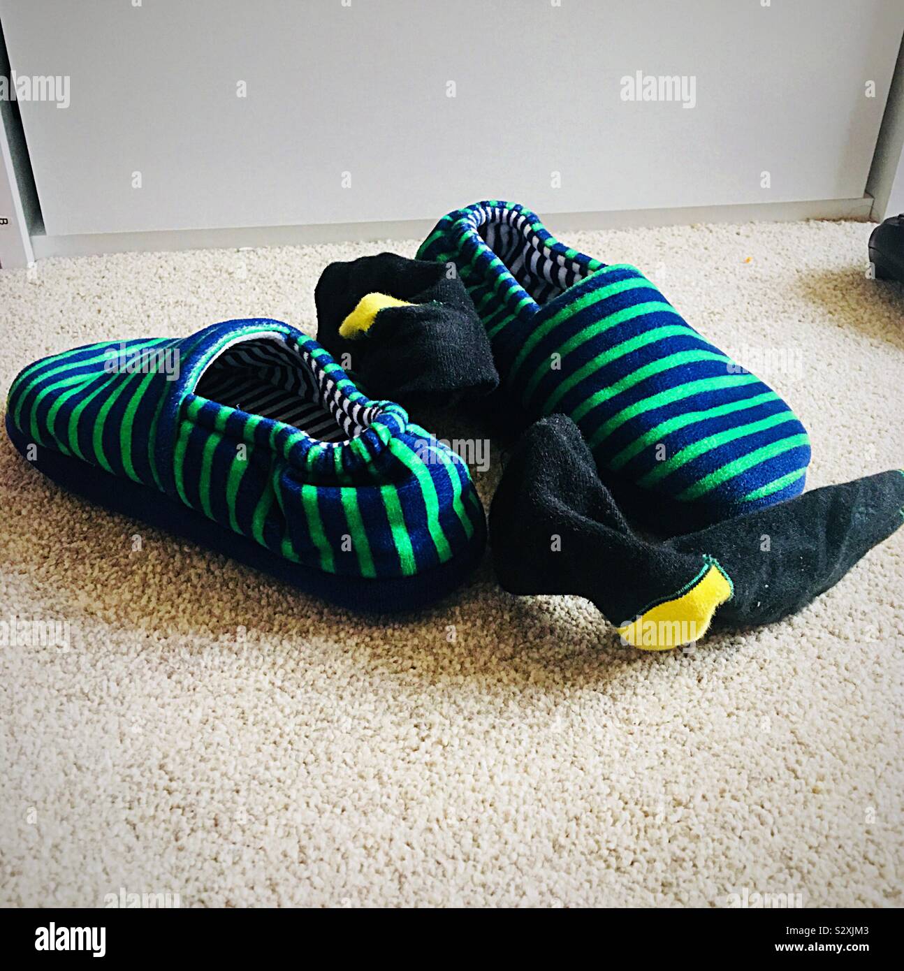 Rayé vert et bleu avec chaussons, chaussettes noir et jaune Banque D'Images