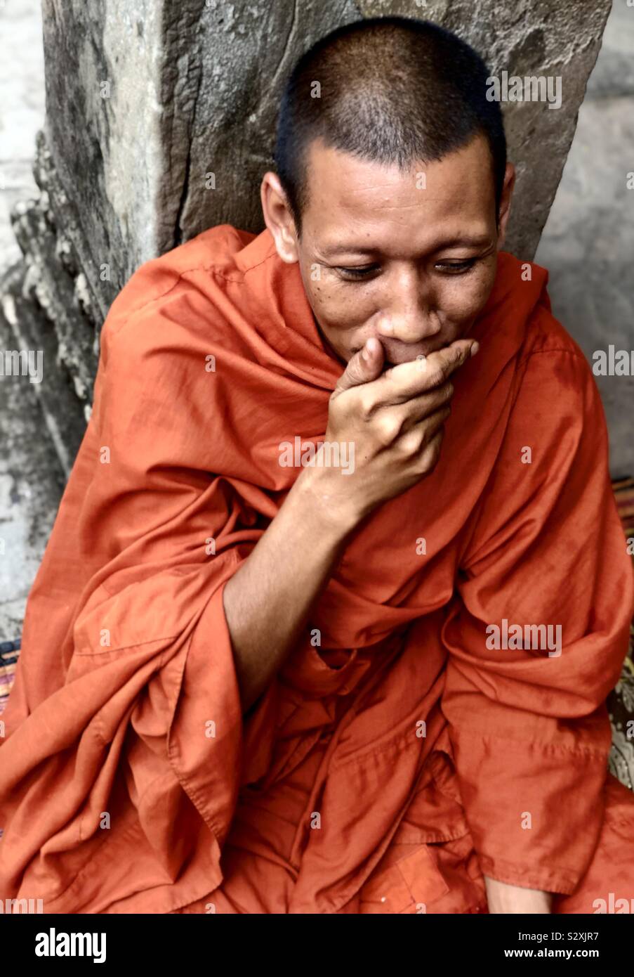 Un moine d'étouffer un rire à Angkor Wat, Siem Reap, Cambodge. Banque D'Images