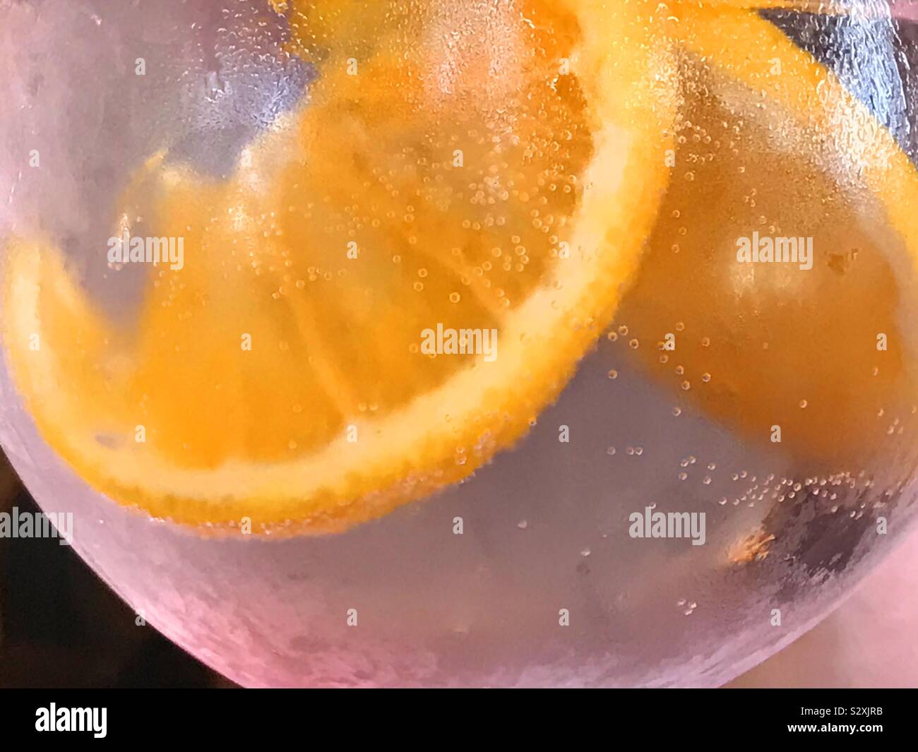 Tranches d'orange flottant dans un verre de liqueur. Banque D'Images