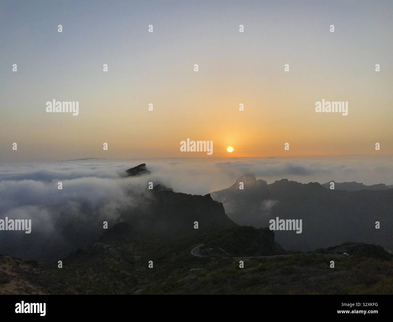 Quelques instants avant le coucher du soleil sur la gorge de Masca sur la côte ouest de Tenerife avec la falaise, piquer à travers les nuages. Îles Canaries - Image de stock capturée avec un smartphone