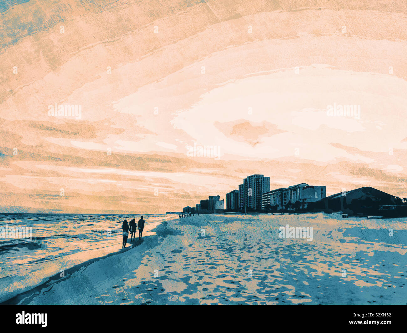 Les gens qui marchent le long d'une plage au coucher du soleil à Destin Florida USA. Banque D'Images