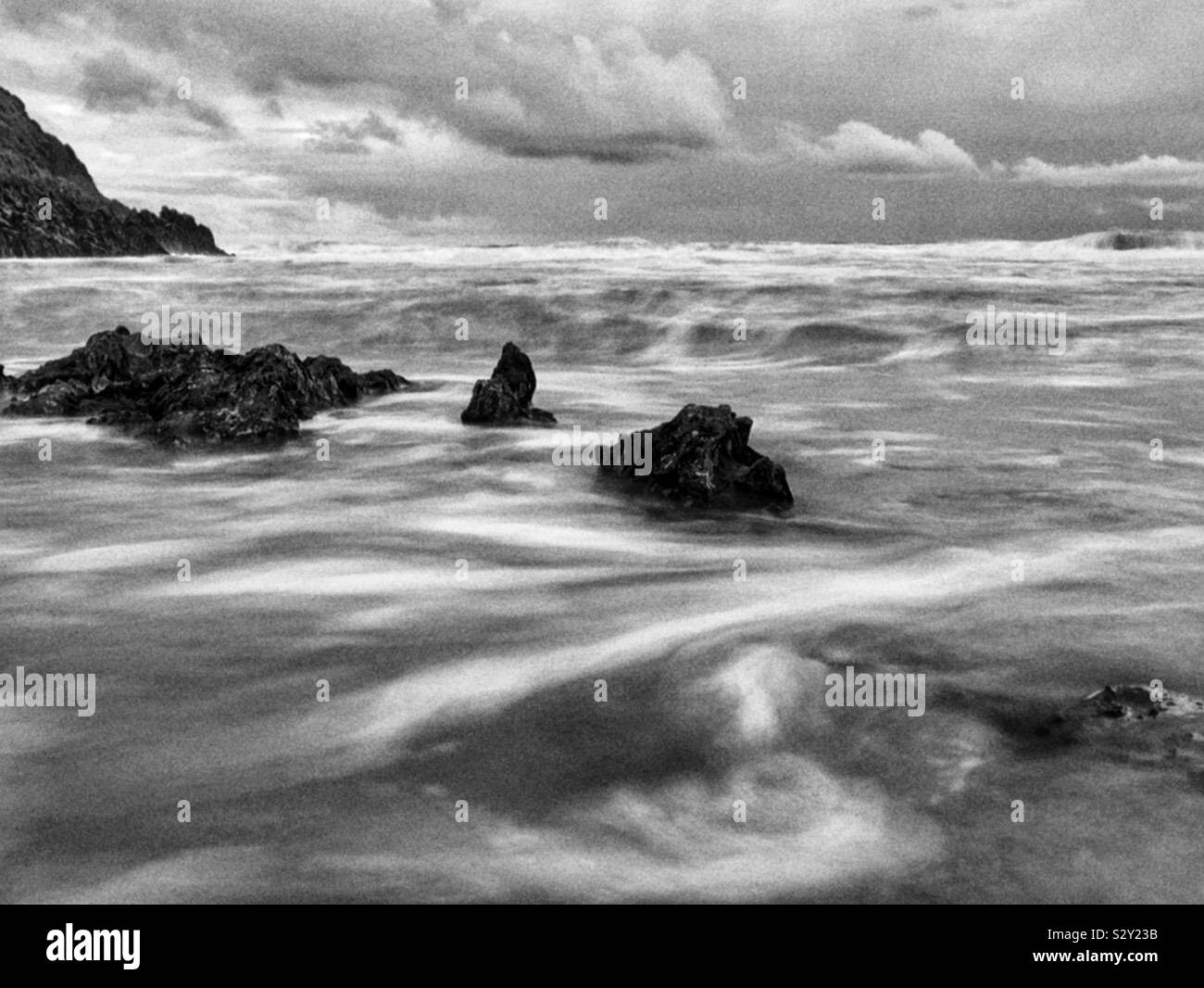 Laver l'eau autour de roches sur une plage de surf gallois, octobre. Banque D'Images