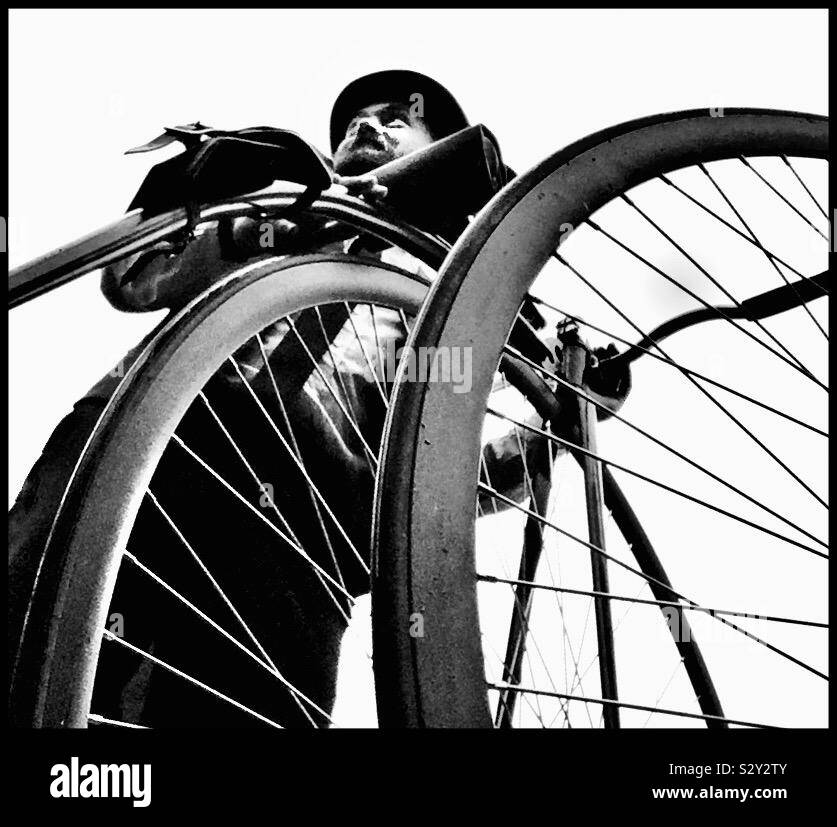 Un homme dans un chapeau tenant un Penny Farthing location. Banque D'Images