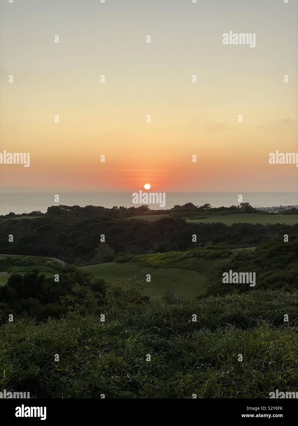 Coucher du soleil avec vue sur l'océan Pacifique et rolling green landscape Banque D'Images