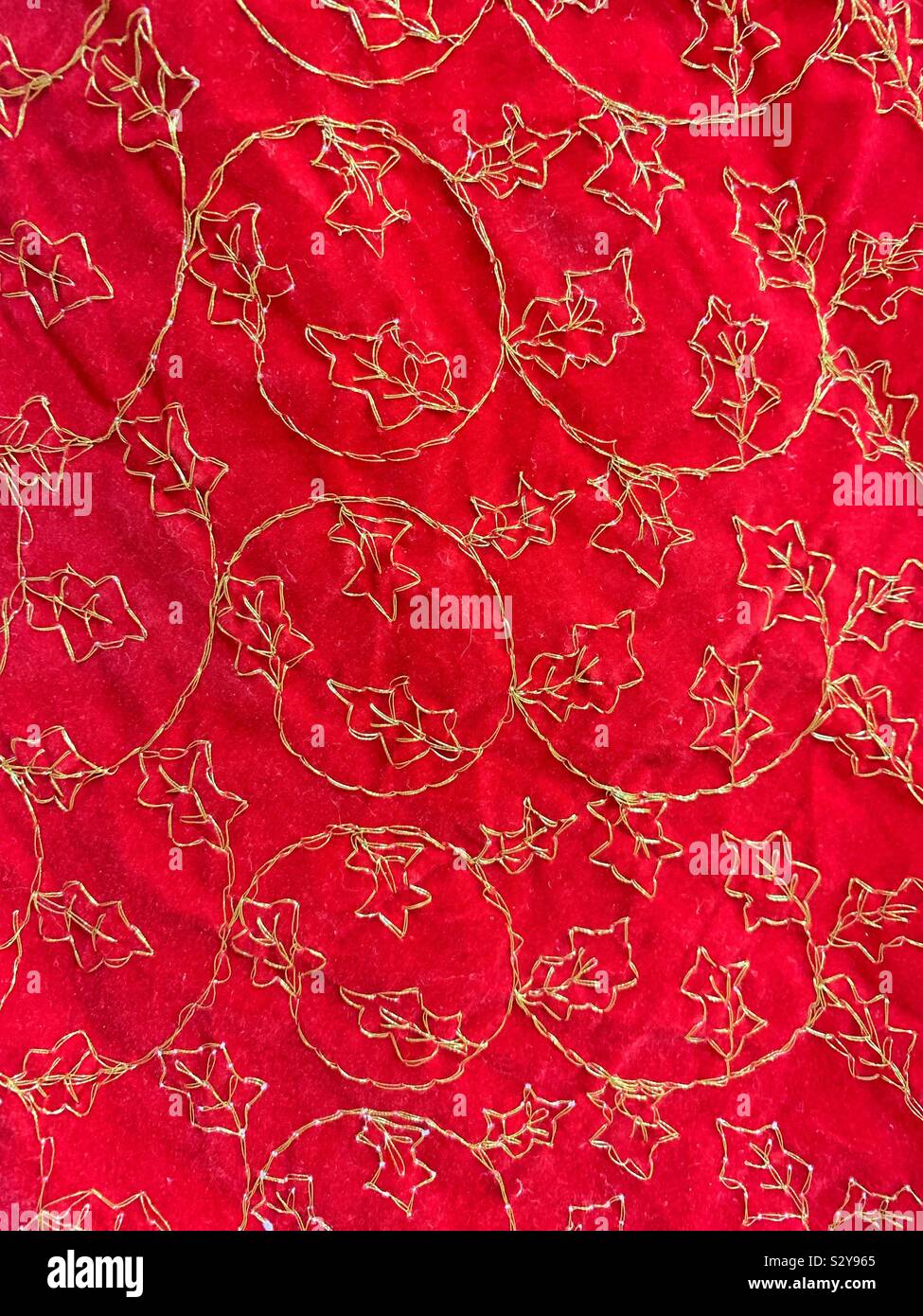 Motif de Noël feuilles cousues sur le velours rouge matériel avec bon string - Image de stock capturée avec un smartphone