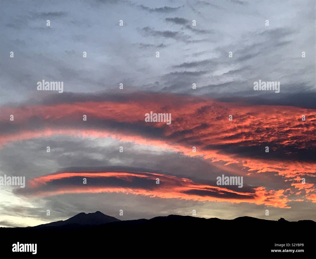 Ciel rouge à l'aube sur le mont Teide. Nuages lenticulaires rouge incandescent. Tenerife Banque D'Images