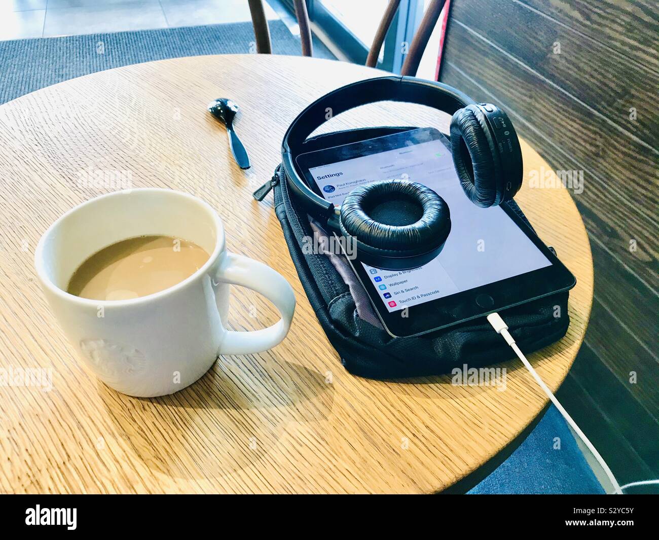 L'utilisation de l'iPad mini coeurs de boire un café Starbucks Banque D'Images