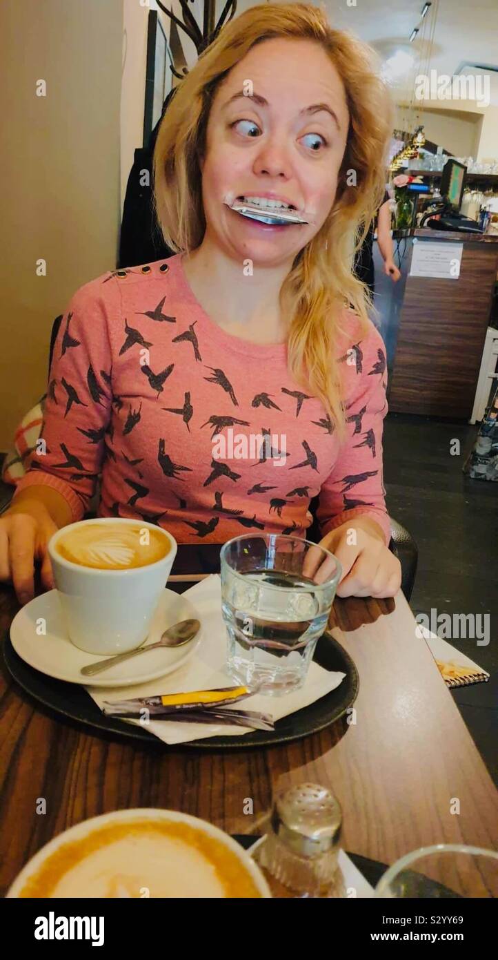 Le café. Fille blonde qui peu un biscuit faire une drôle d'expression. Bratislava, Slovaquie Banque D'Images