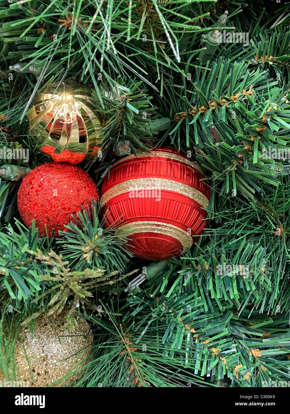 Beau rouge et or ornements d'arbre de Noël suspendus dans un pin - Image de stock capturée avec un smartphone