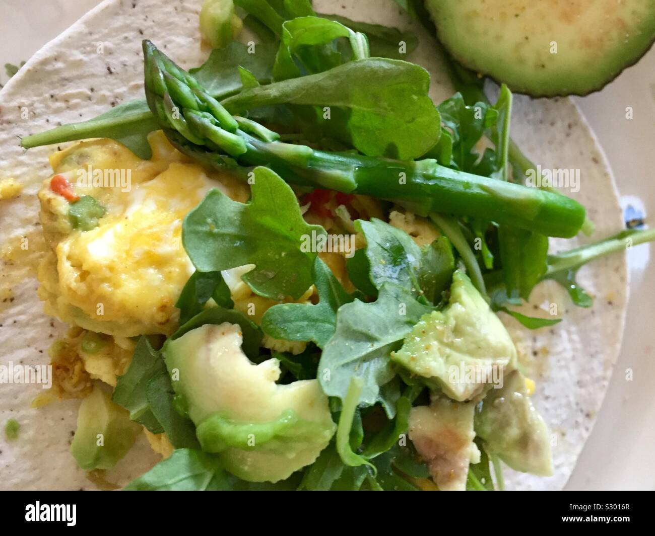 Tortilla de farine de noix de coco avec des œufs brouillés, roquette, asperge, avocat Banque D'Images