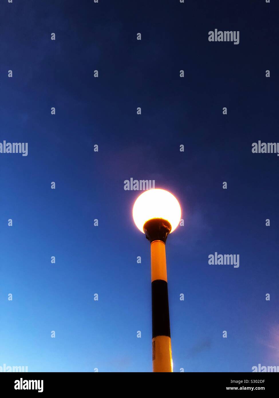 Belisha beacon clignotant à la tombée de la - Image de stock capturée avec un smartphone
