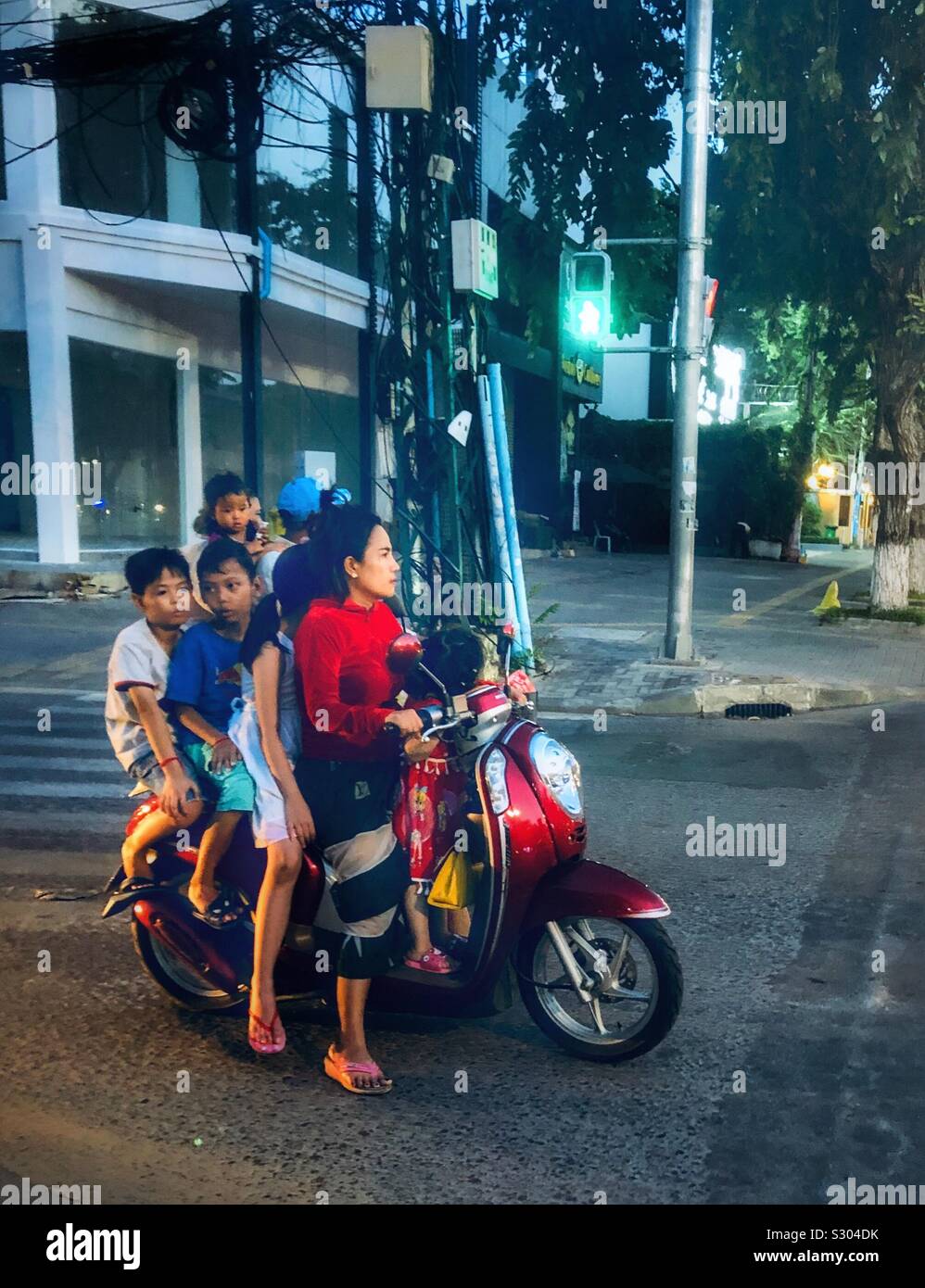 Une mère et ses enfants voyageant sur un cyclomoteur au Cambodge. Banque D'Images