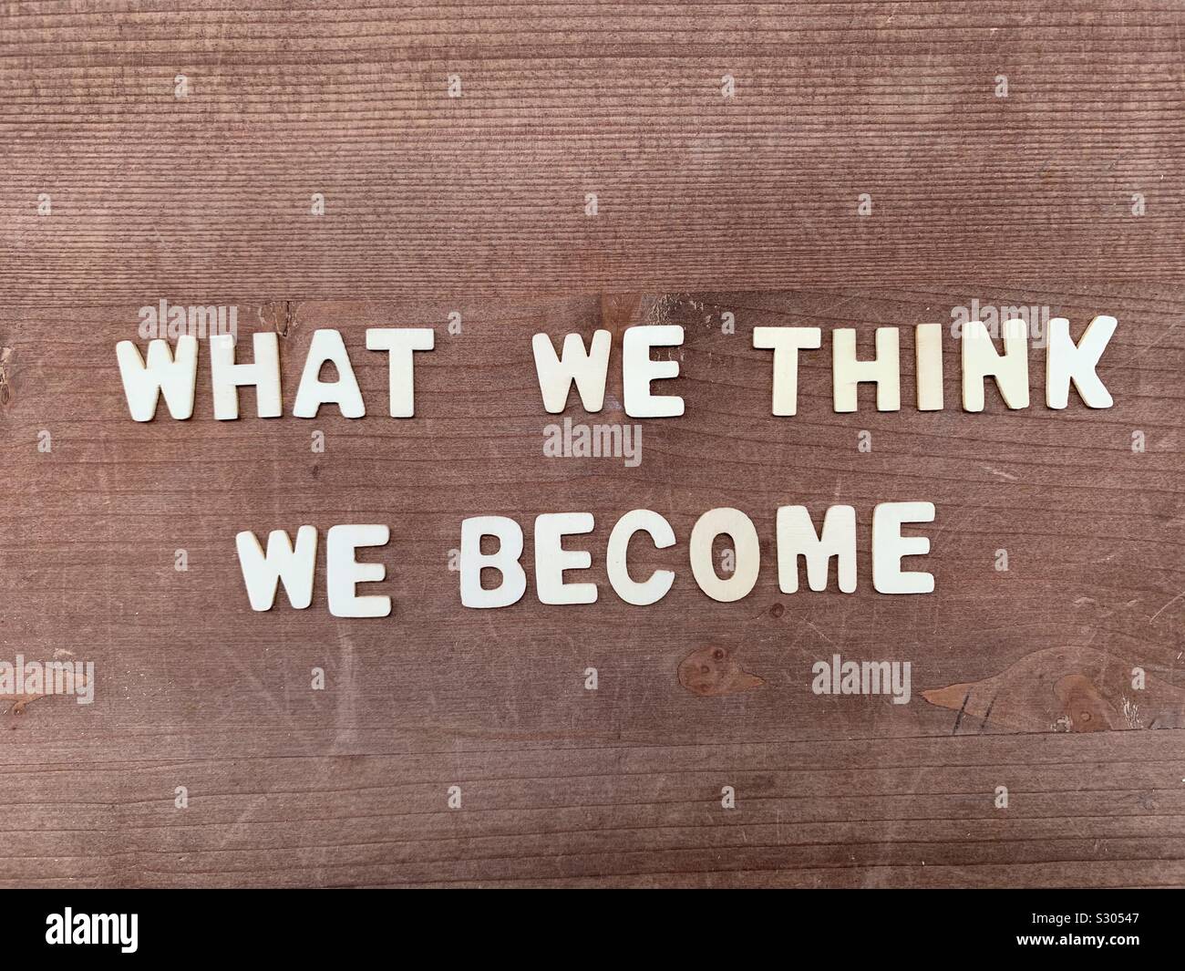 Ce que nous pensons, nous devenons, Bouddha citer composé avec des lettres sur une planche en bois - Image de stock capturée avec un smartphone