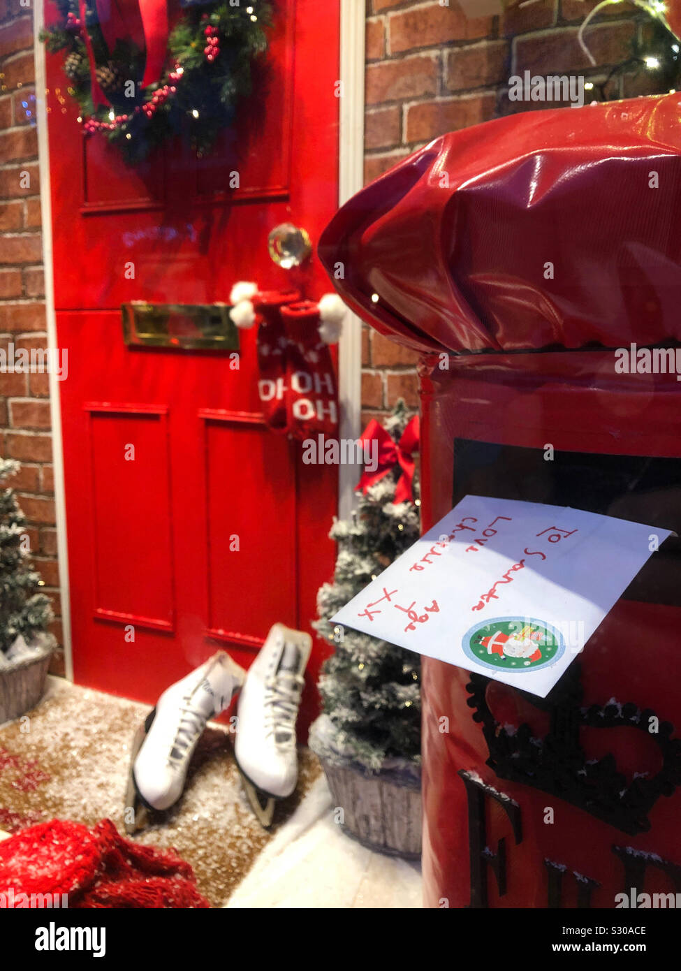 Cher Père Noël lettre dans une boite aux lettres à l'extérieur d'un twee Christmassy porte avant. Banque D'Images