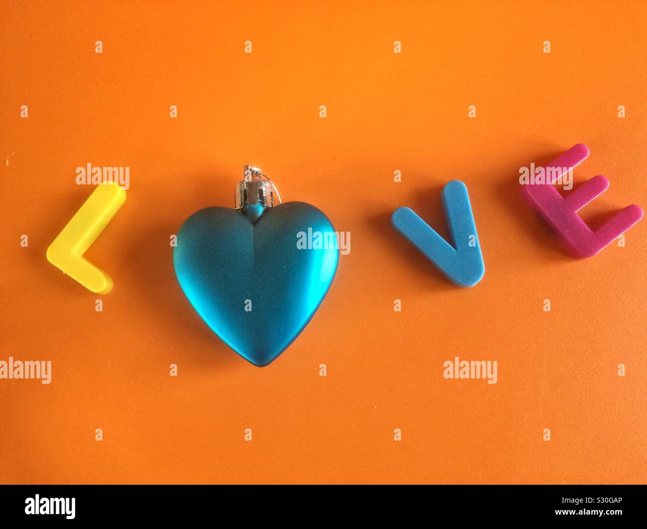 Mot amour close-up faite avec lettres colorées et d'un bleu brillant coeur Banque D'Images