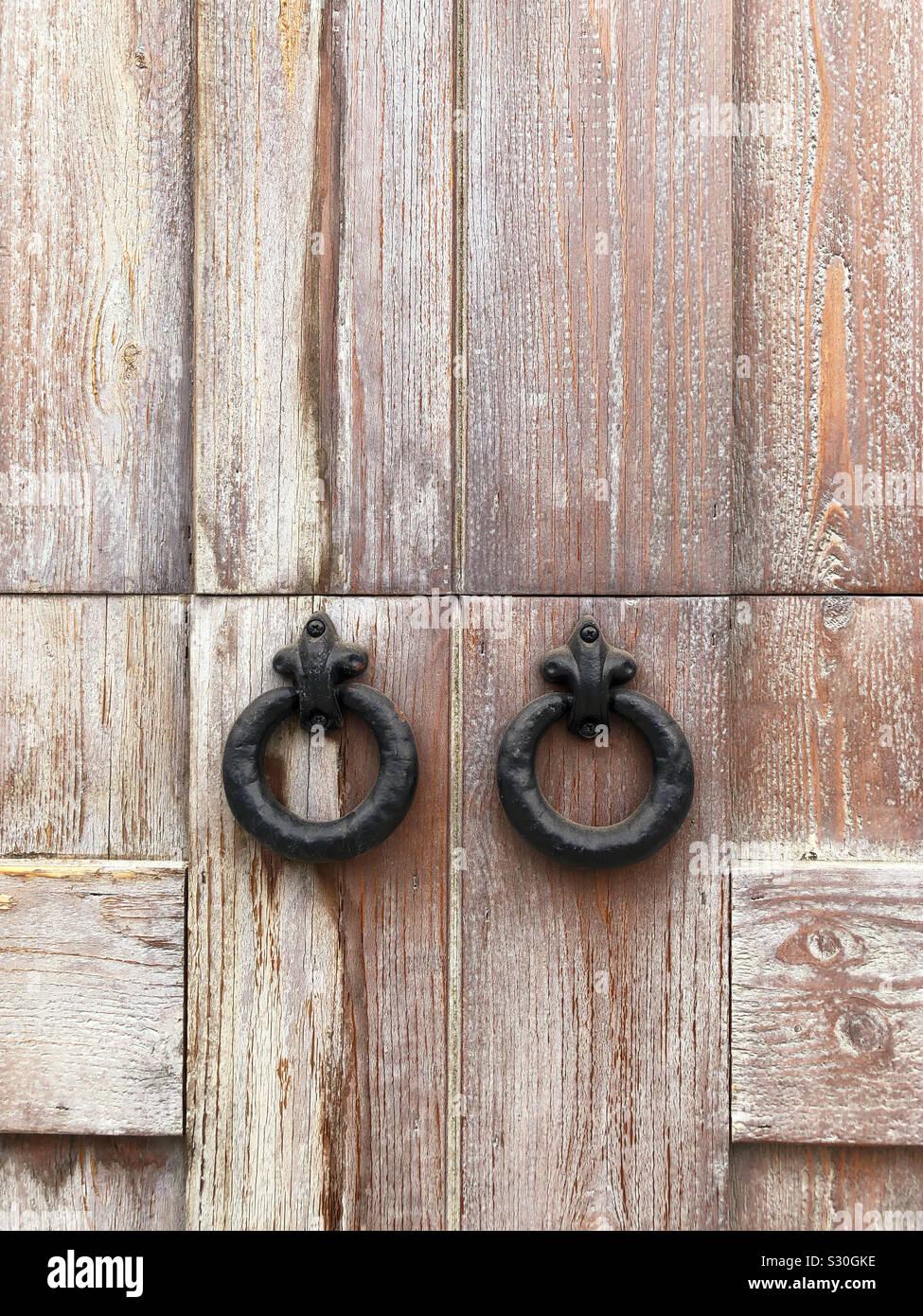 De près, les poignées de porte de fer sur la porte en bois. Banque D'Images