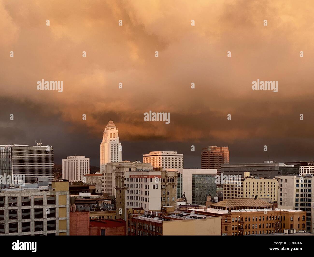 LOS ANGELES, CA, DEC 2019 : recherche à travers le centre-ville à l'Hôtel de Ville avec cuivre-dramatique nuages orange au crépuscule - Image de stock capturée avec un smartphone