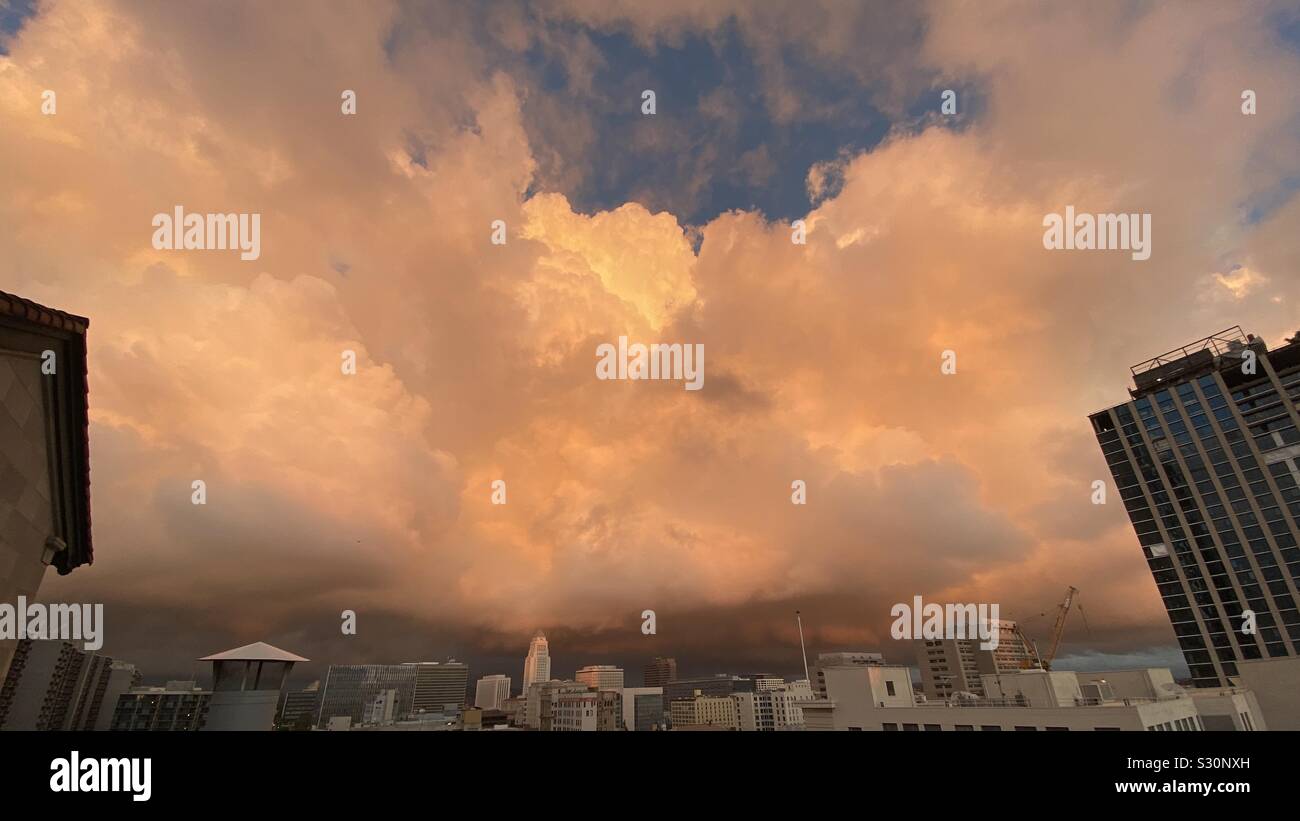 LOS ANGELES, CA, DEC 2019 : large vue sur le centre-ville avec l'Hôtel de Ville à distance et dramatique nuages orange passage au crépuscule - Image de stock capturée avec un smartphone