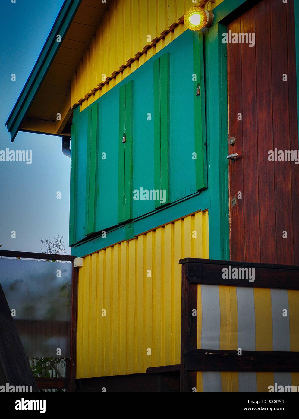 Chalet de bois peint en jaune avec des volets verts et allumé à l'extérieur de l'ampoule, Suède Banque D'Images