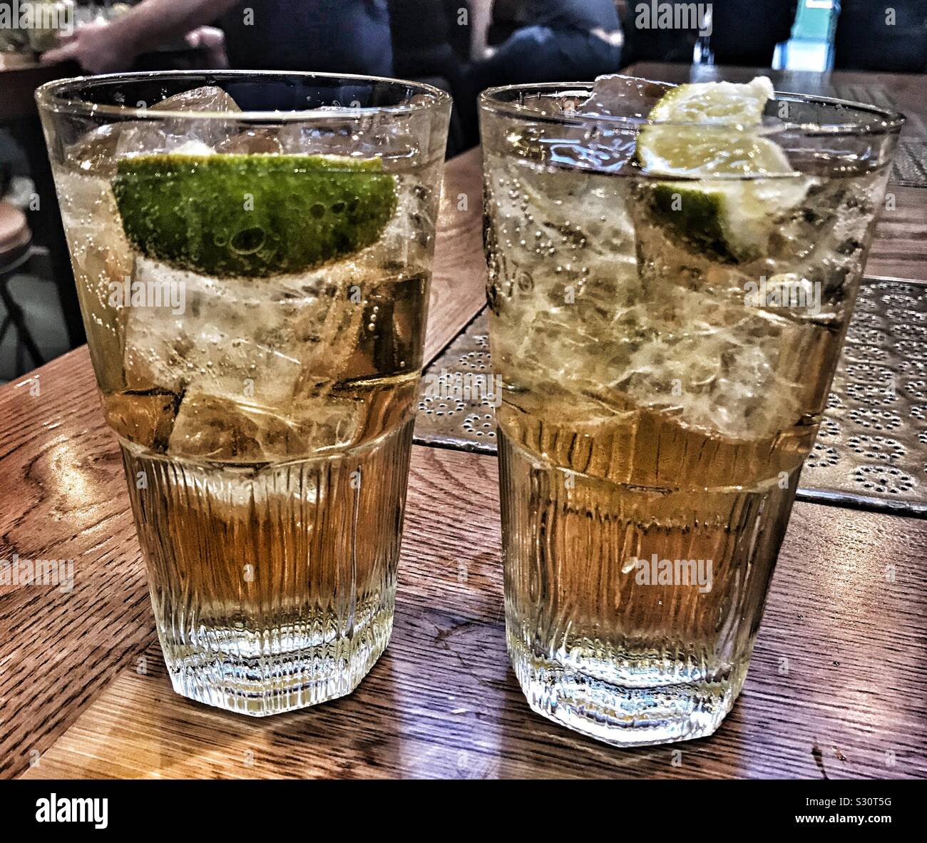 Deux verres de whisky avec le soda au gingembre et citron vert Banque D'Images