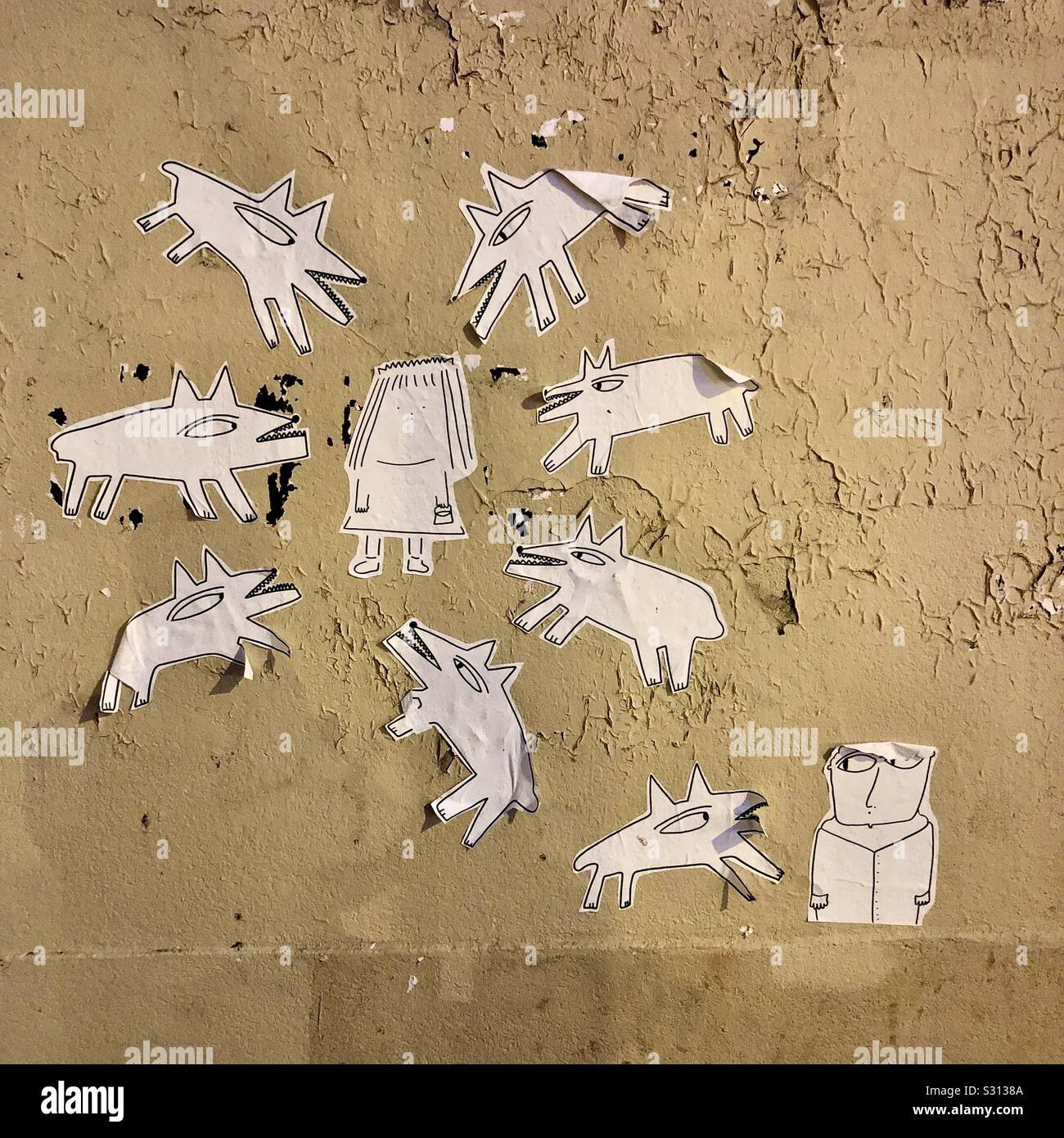 Coupe-papier graffiti de chiens autour d'une femme - Paris 11ème arrondissement, France. Banque D'Images