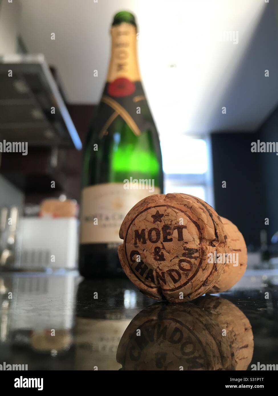 Le bouchon d'une bouteille de Moët et Chandon se trouve sur un comptoir en granit haut dans une cuisine. Banque D'Images