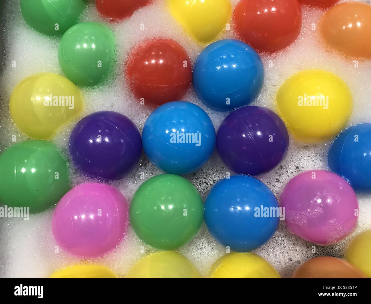 Boules colorées dans de l'eau savonneuse Banque D'Images