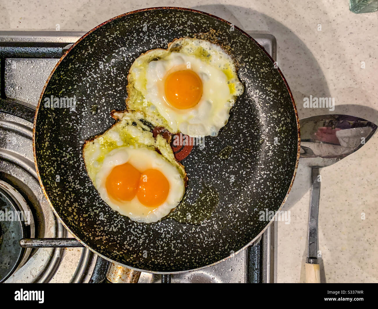 Œufs frits dans une poêle, dont un œuf de jaune double Banque D'Images