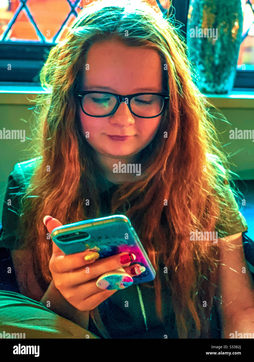 Jeune fille regardant iphone Banque D'Images