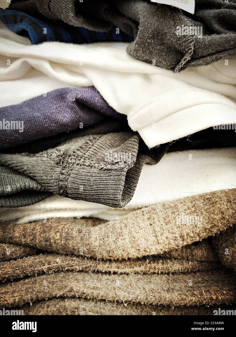 Gros plan sur une pile de repassage. Vue latérale des vêtements, des t-shirts, des cavaliers empilés prêts pour les corvées de blanchisserie. Vue détaillée des vêtements pour hommes. Banque D'Images