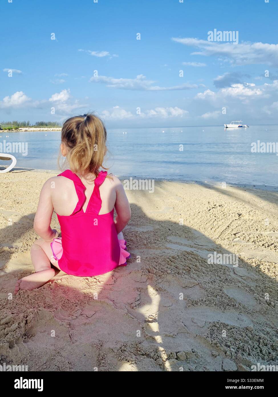 Petite fille regardant la mer sur la plage Banque D'Images