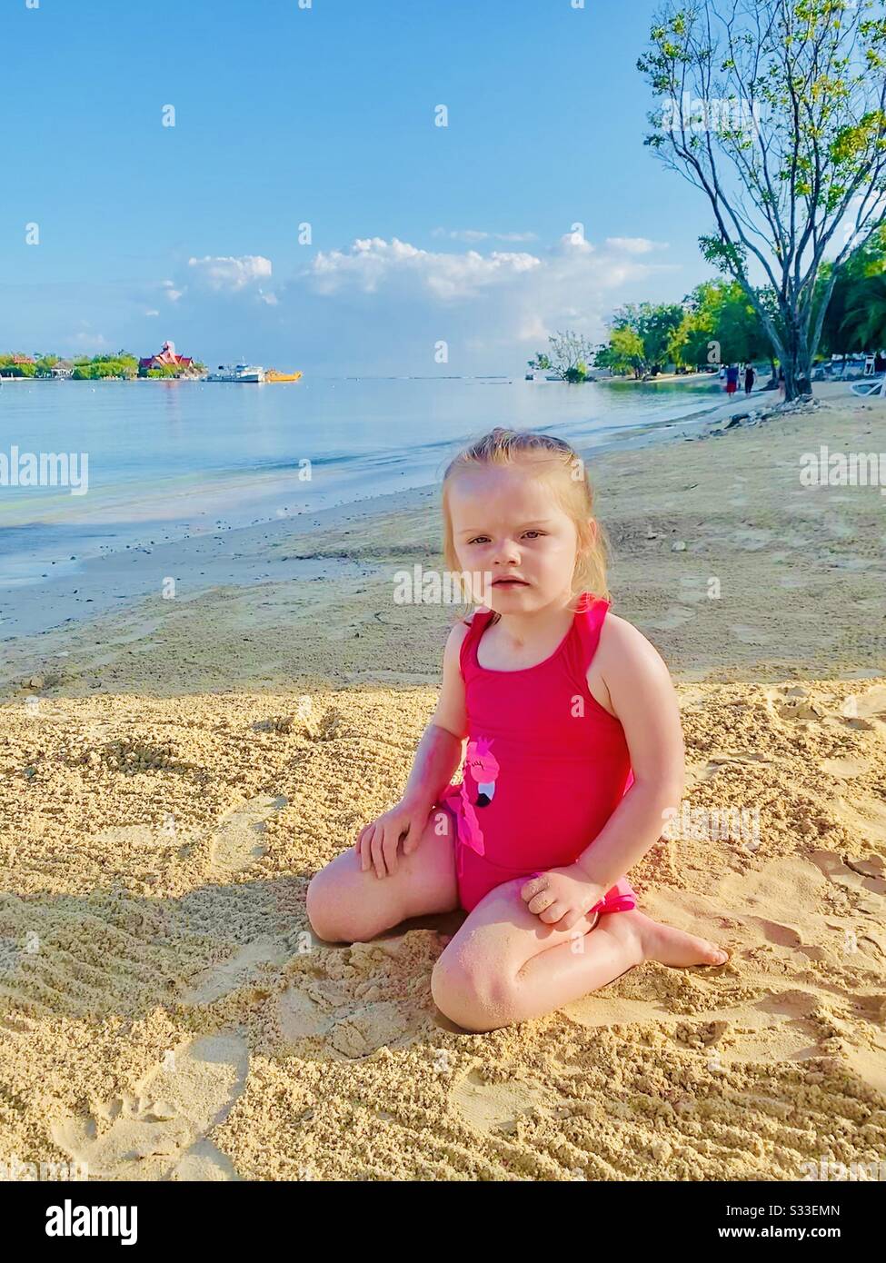 Petite fille sur la plage posant Banque D'Images
