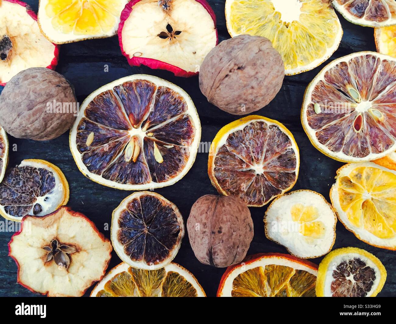Sécher les fruits sur une table rustique en bois comme les tranches d'orange, les tranches de pomme et les noix - Image de stock capturée avec un smartphone