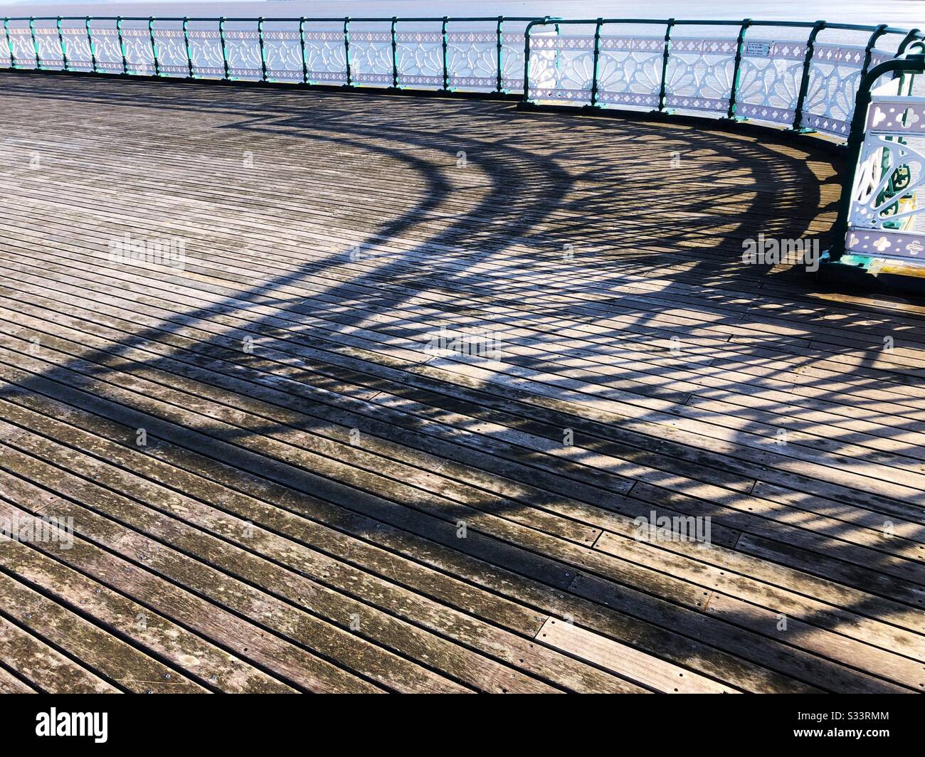 Ombres des rampes sur les planchers en bois de la jetée de Penarth, Pays de Galles du Sud, fin d'après-midi, mars. Banque D'Images