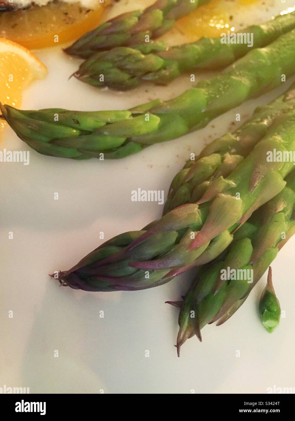 Des asperges fraîchement cuites épient sur une assiette blanche pour le dîner - Image de stock capturée avec un smartphone
