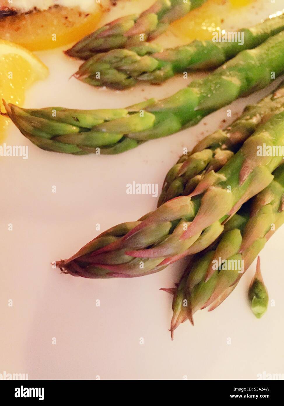 Des asperges fraîchement cuites épient sur une assiette verte pour le dîner - Image de stock capturée avec un smartphone
