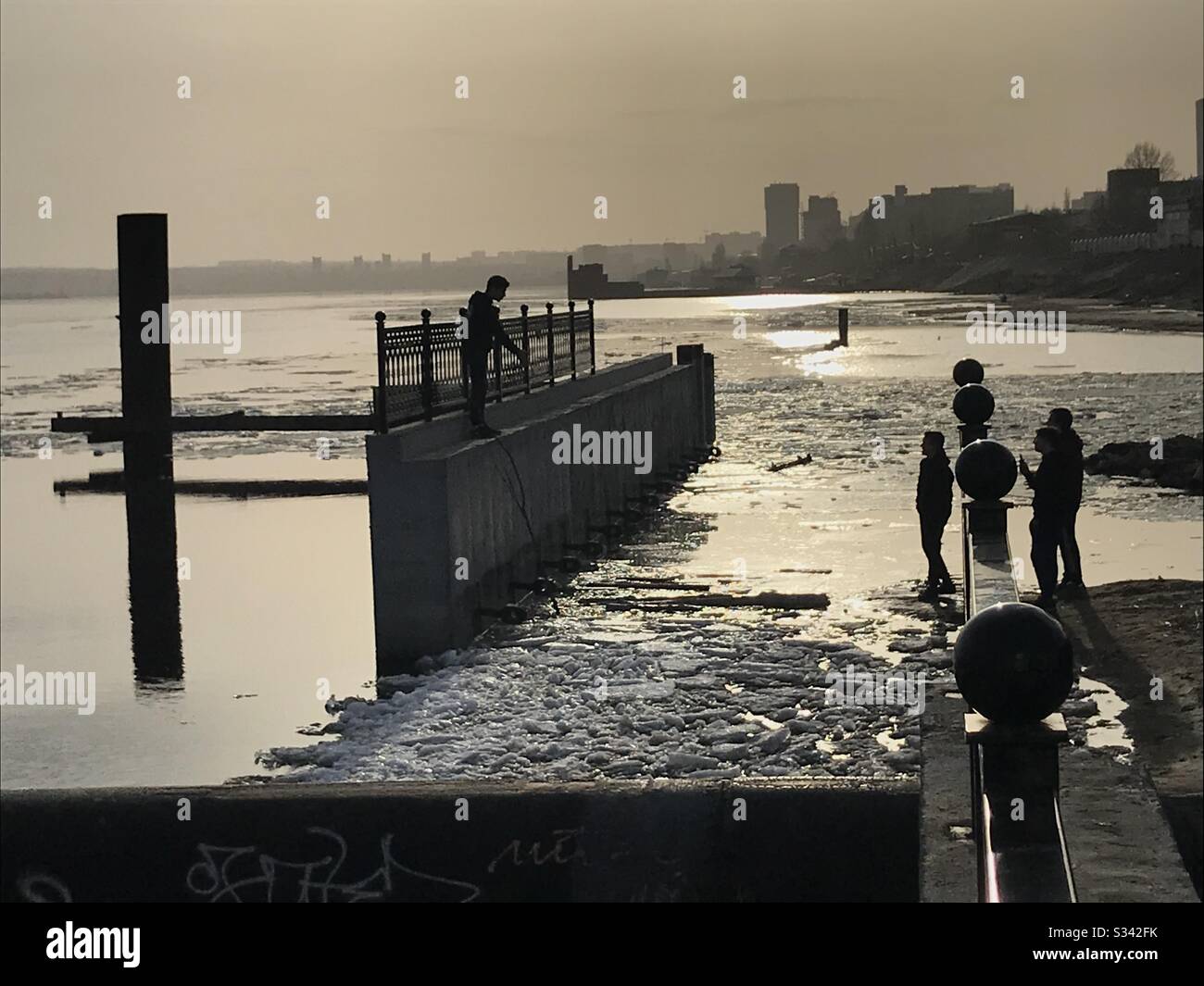 Adolescents sur remblai abandonné pendant la dérive de glace sur la rivière Volga. Début printemps, Saratov, Russie Banque D'Images