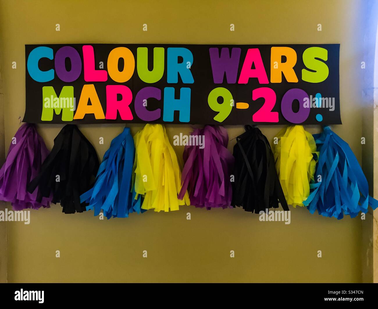 COVID-19, dans de nombreuses couleurs. Un signe audacieux avec des liens en tissu sur le mur. Coïncide heureusement avec la Saint Patrick. Un festival de couleur, Canada. Conception. Lettres. Chiffres - Image de stock capturée avec un smartphone