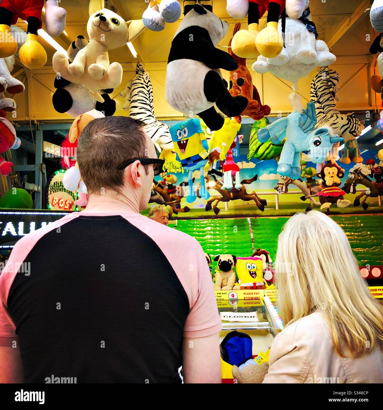 Deux personnes, mère et fils, sont vues de derrière. Stand d'un stand de prix du parc des expositions avec jouets rembourrés Banque D'Images