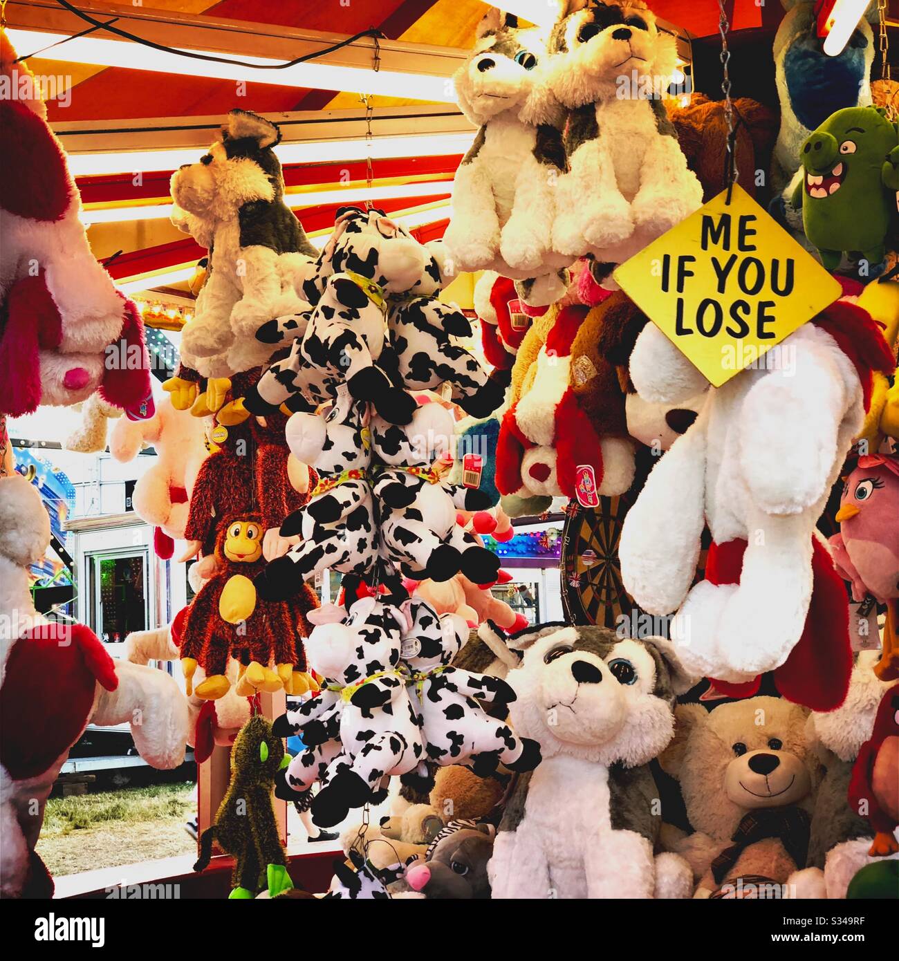 Moi si vous vous accrochez aux jouets rembourrés et aux ours en peluche dans un stand de prix du parc des expositions itinérant. Copier l'espace vers la gauche - Image de stock capturée avec un smartphone