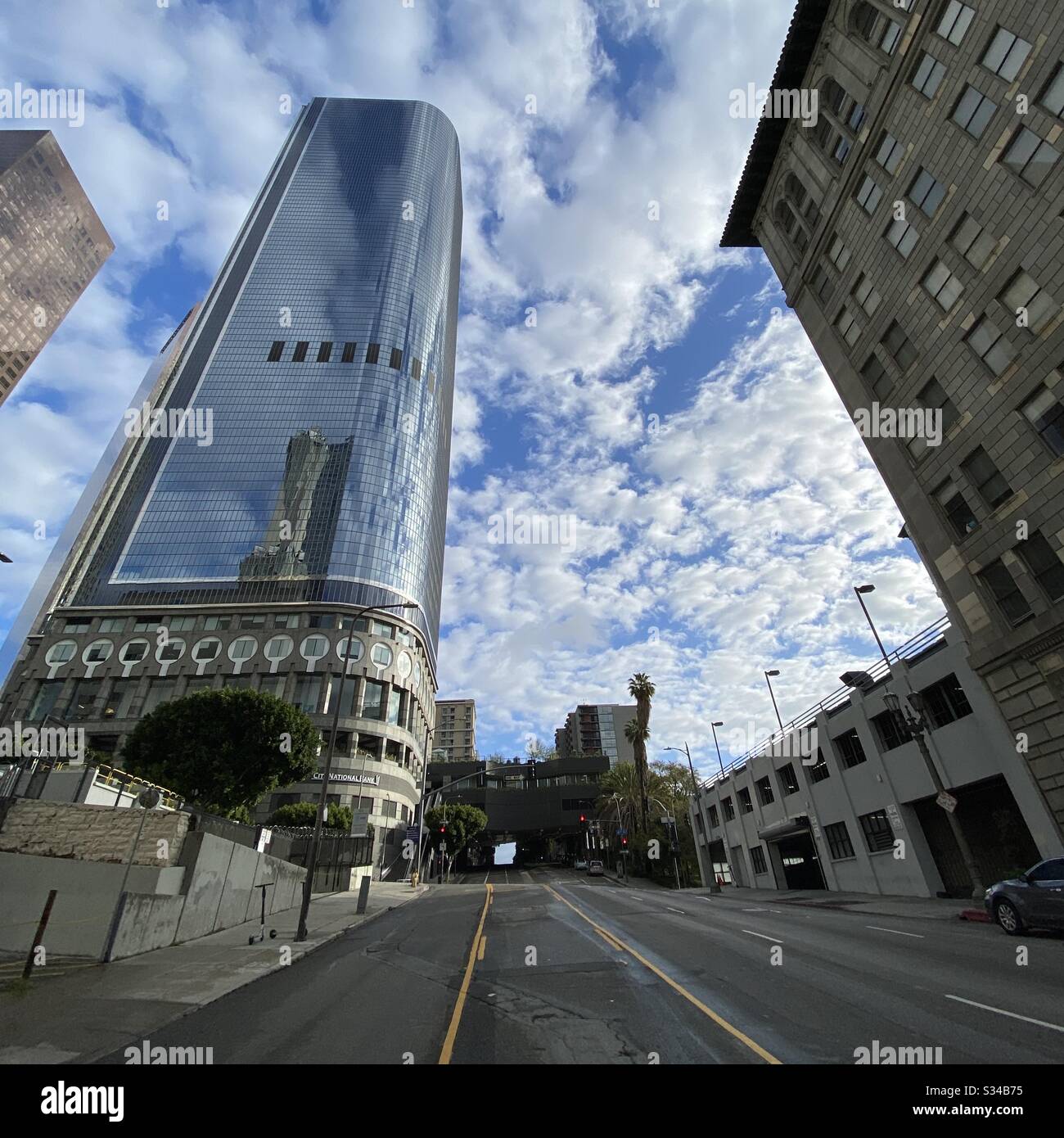 LOS ANGELES, CA, MARS 2020: Les nuages et le ciel bleu reflètent dans des fenêtres sur le gratte-ciel et les bâtiments à proximité de California Plaza dans le quartier financier du centre-ville - Image de stock capturée avec un smartphone