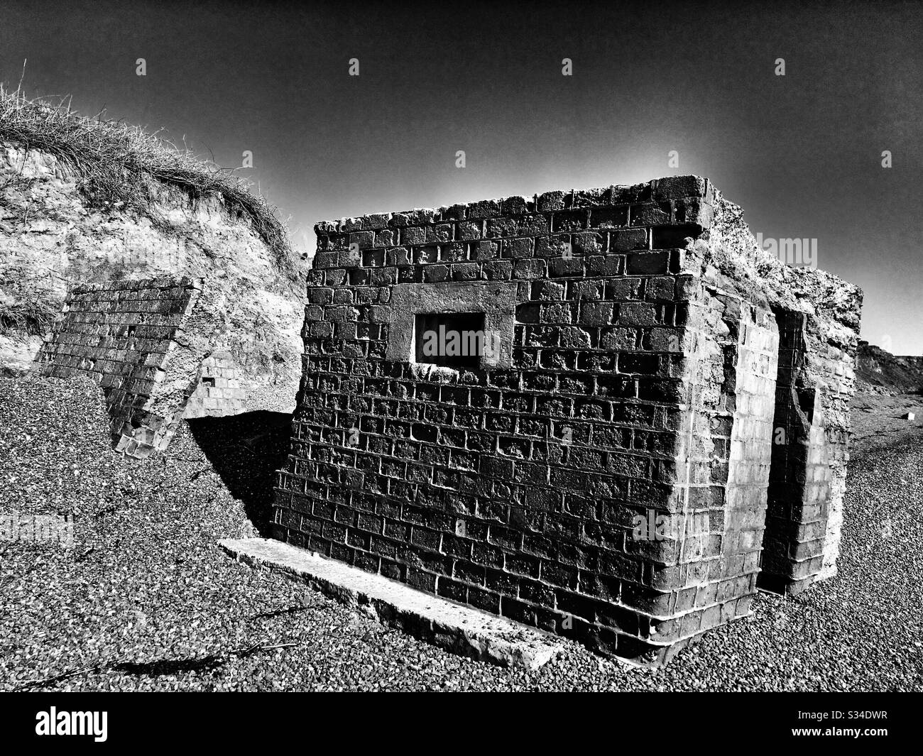 Un bunker en béton en temps de guerre est tombé sur une plage en raison de l'érosion côtière Banque D'Images