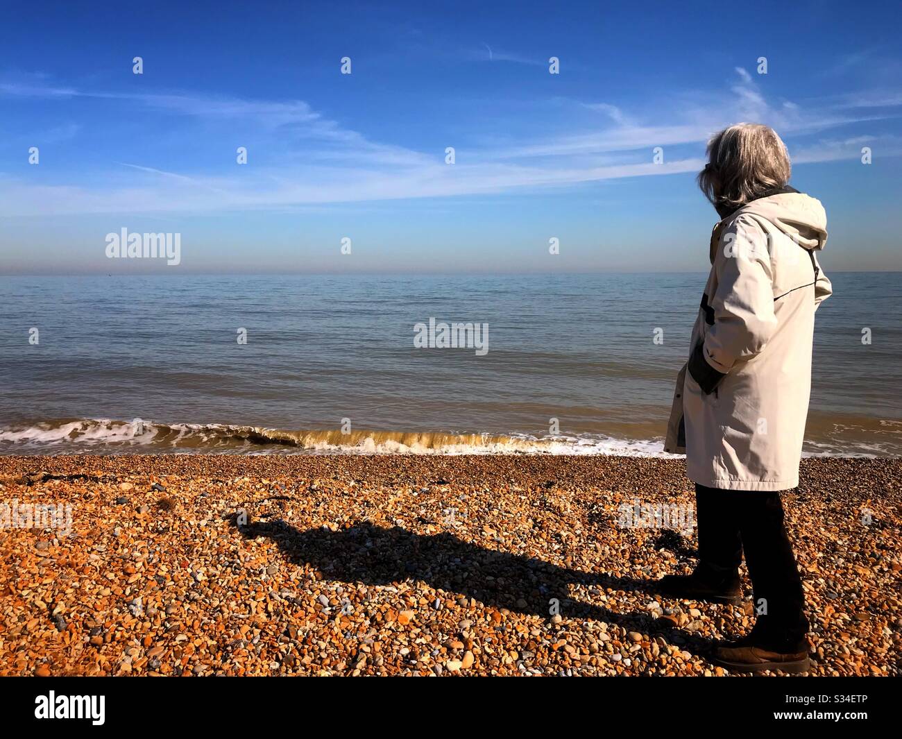 Femme dans ses années 70 distanciation sociale par la mer Banque D'Images