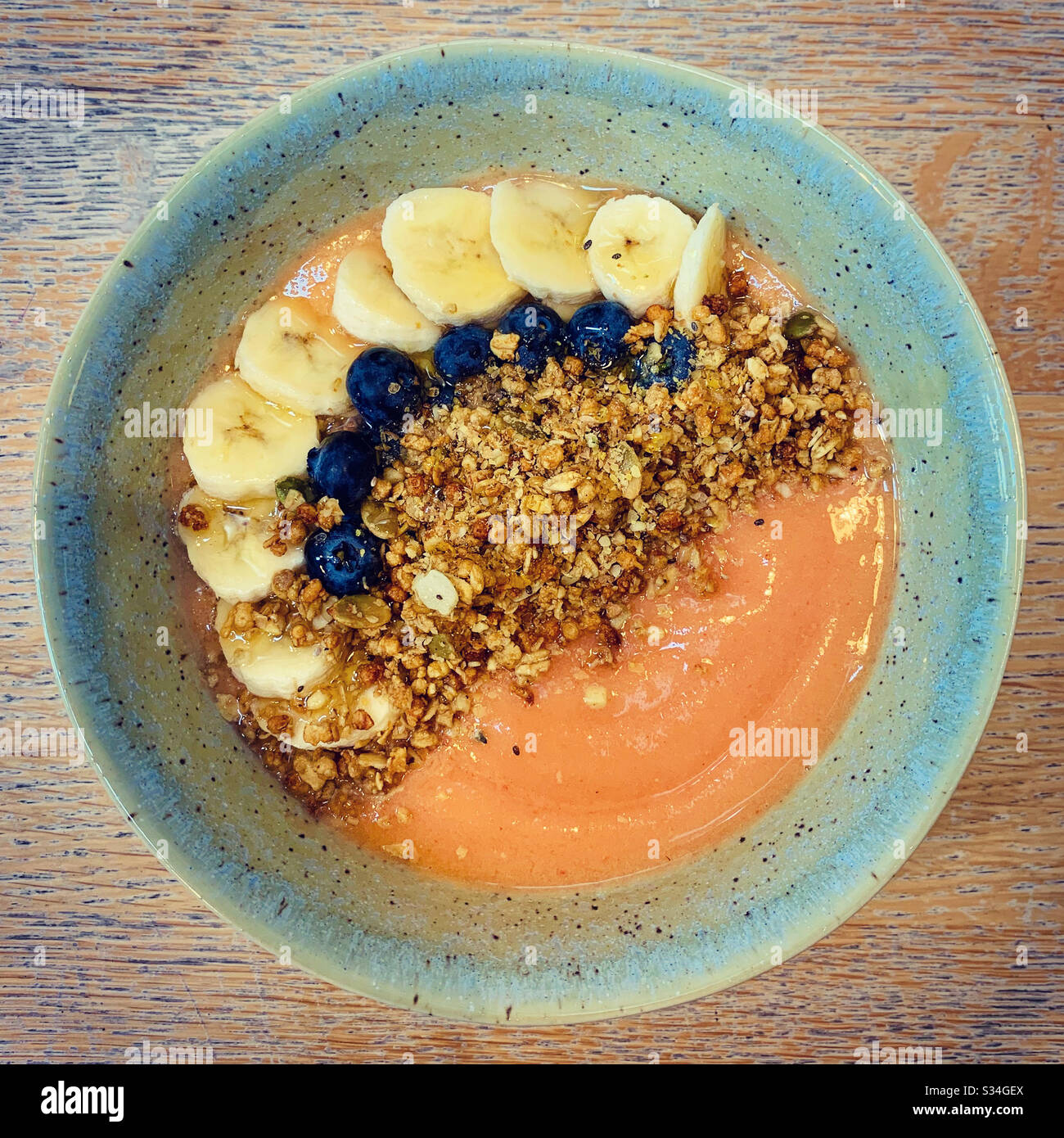 Bol de smoothie à la mangue avec de la granola, des bananes et des bleuets Banque D'Images