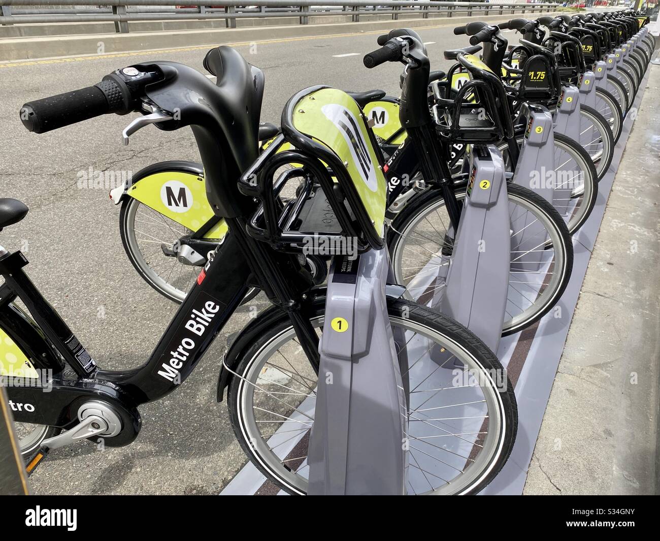 LOS ANGELES, CA, MARS 2020: Vue le long de la rangée de vélos noirs et verts LA Metro Partagez des vélos de location alignés dans le quai près des musées du centre-ville - Image de stock capturée avec un smartphone